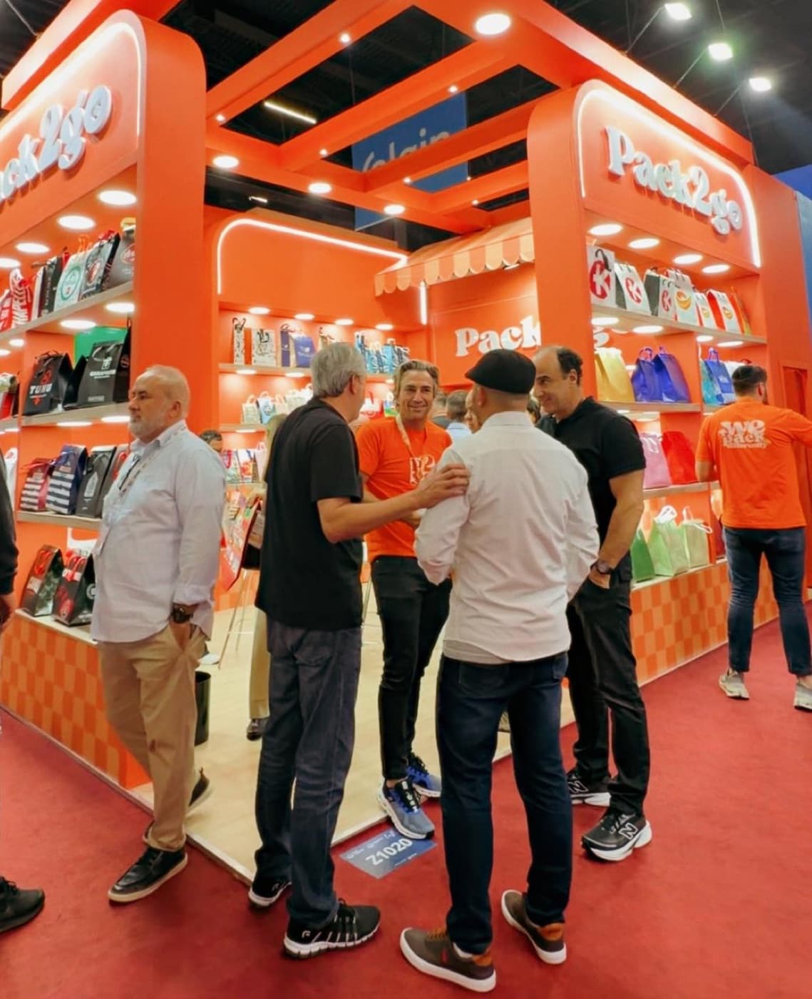 Equipe Pack2Go conversando com visitantes no estande.
