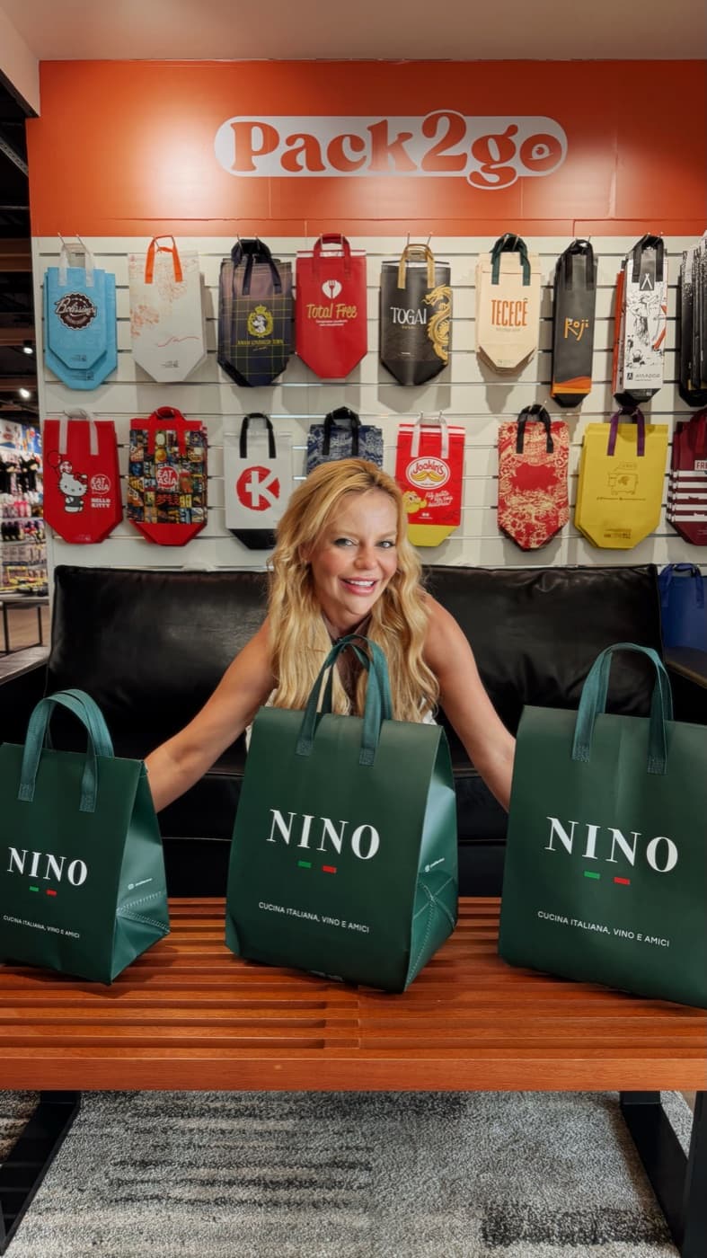Cliente segurando sacolas térmicas personalizadas da marca Nino.